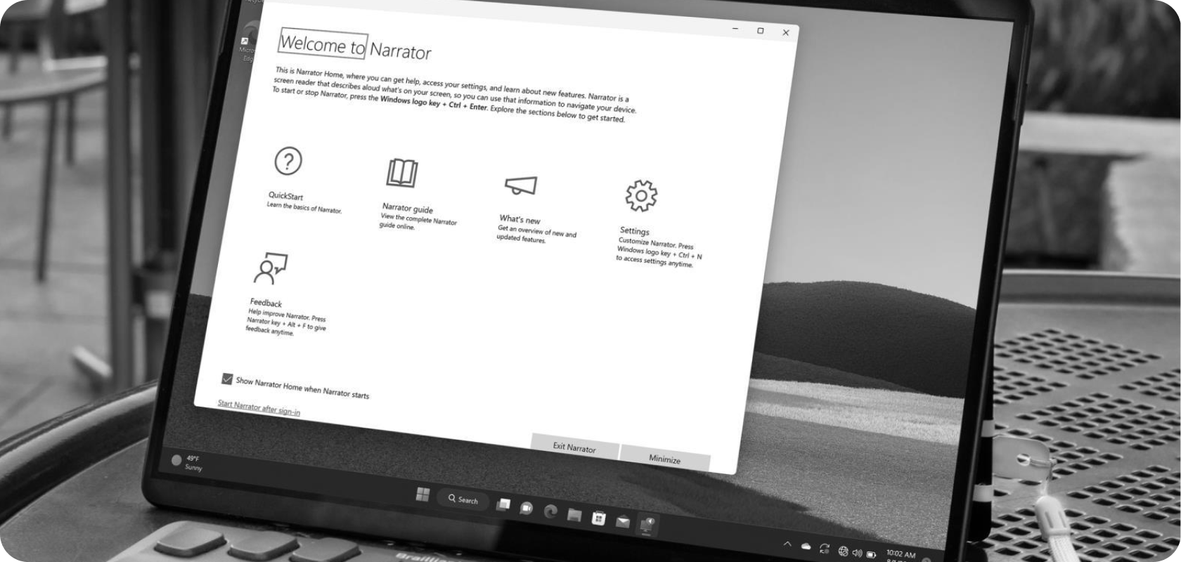 Laptop showing Narrator welcome screen with a connected braille display.