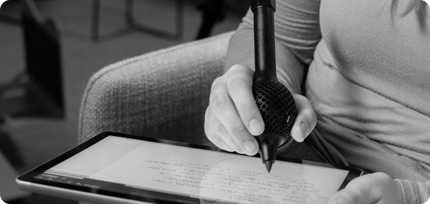 Person using a stylus to write on a tablet.