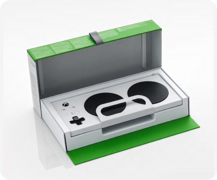 The Xbox Adaptive controller in its packaging with the lid open.